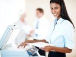 9550500-portrait-of-a-pretty-business-woman-making-copies-on-the-photocopy-machine-at-office